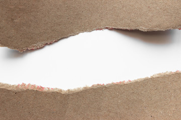 Brown corrugated texture paper torn on white background. rip of cardboard sheet used as a background .