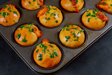 Tasty homemade little buns with garlic and herbs on a wooden background