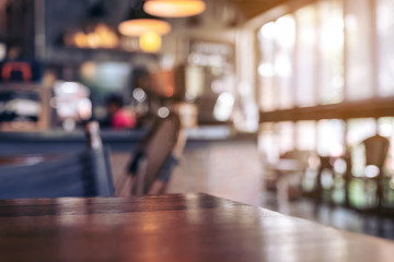 Wooden table with blurred background in cafe - obrazy, fototapety, plakaty