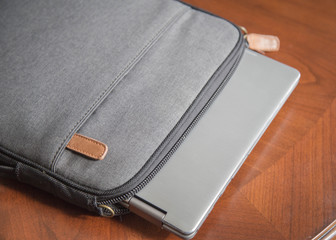 laptop sitting on wooden table with case and glasses. good for a writer, editor, author or...