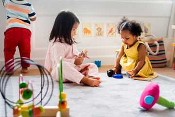 Little kids playing toys in the playroom - obrazy, fototapety, plakaty