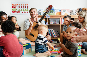 Nursery children playing with musical instruments in the classroom - obrazy, fototapety, plakaty
