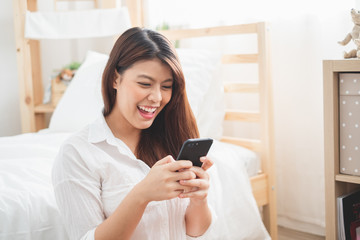 Beautiful Asian woman using laptop and smart phone in bed room for online shopping, Asian woman lifestyle concept