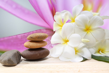 Fototapeta na wymiar Zen spa concept background - Zen massage stones with frangipani plumeria flower