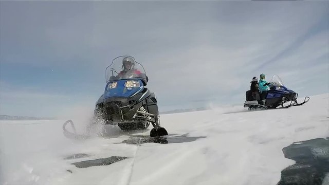 Aerial view snowmobiles ride on the frozen Lake Baikal in winter