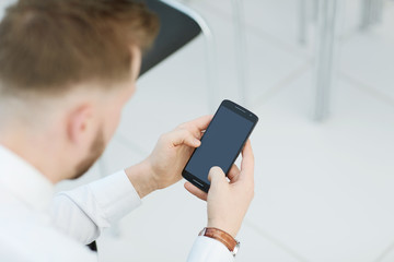 close up.businessman looking at the screen of his smartphone