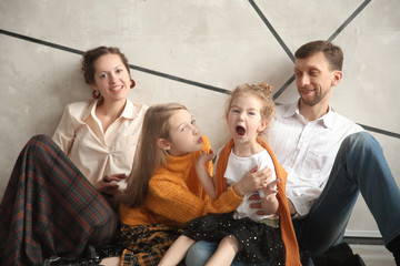 happy family sitting on the floor in a new house on Christmas eve