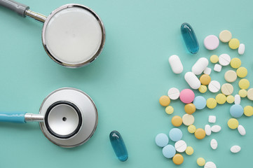 Different medication with stethoscope on blue background