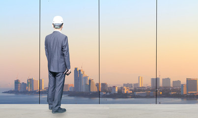 Fototapeta premium businessman is standing at office and looking big city