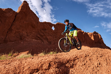 Cyclist riding a mountain bike downhill style in a canyon 