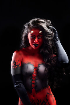 sexy asian woman with long black hair wearing fantasy red and black devil body paint costume