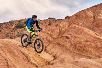 Fototapeta na wymiar Cyclist riding a mountain bike downhill style in a canyon 