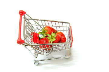 Fresh strawberries in shopping cart on white background.