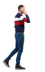 Fototapeta premium a side view of man walking with a mobile phone.