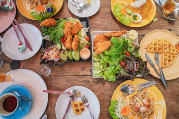 Different salad and snack on the wooden table top view