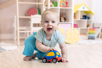 funny baby boy playing toy in nursery or kindergarten - 247499872