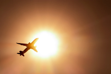 airplane flying through the sun