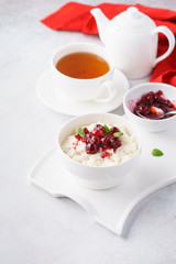 Fototapeta na wymiar Rice porridge with cranberries, jam and tea for breakfast.