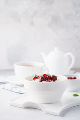 Bowl of rice porridge with cranberries and jam for breakfast.