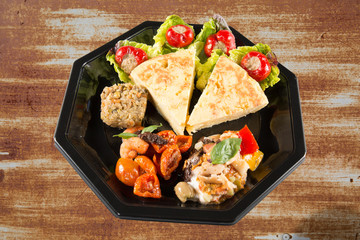 Spanish Omelette served in slices. Tortilla de patatas. brown grungy wall background for takeaway