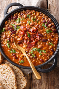 American cowboy beans with ground beef, bacon in a spicy sauce close-up. Vertical top view