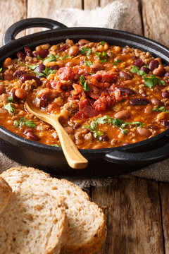 cowboy bean stew with ground beef, bacon in a spicy sauce close-up in a bowl. vertical
