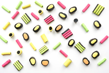 Colorful lollipop and licorice candy on white. View from above. Concept banner for design. Flat lay.