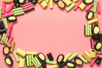 Colorful lollipop and licorice candy on pink. View from above. Concept banner for design. Flat lay.