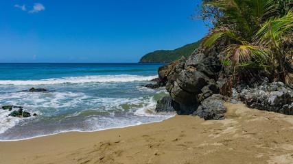 Fototapeta na wymiar Ein Strand mit Felsen und Wellen in Punta Cana, Atlantik, nördlich des Äquators