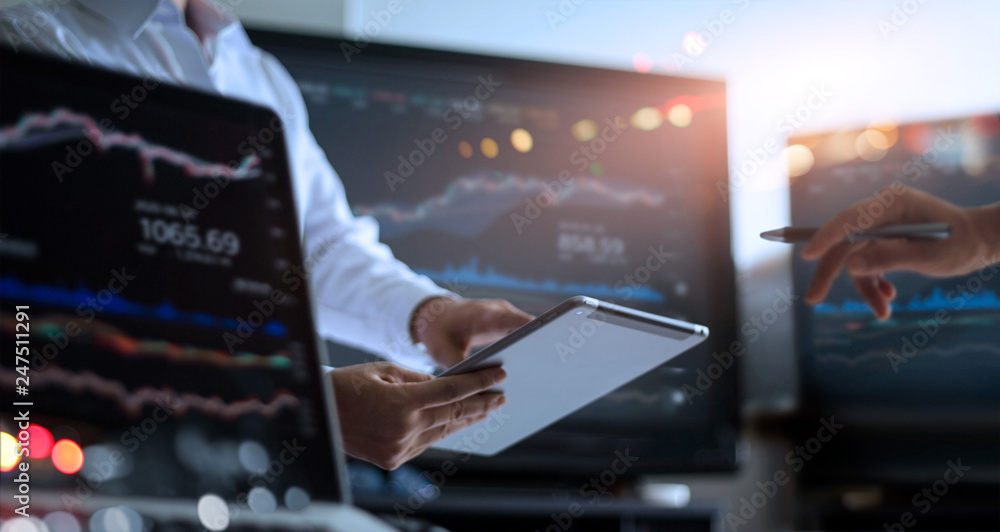 Poster Business team working together. Businessman using tablet for analyzing data stock market in monitoring room with team pointing on the data presented in the chart, financial investment concept.
