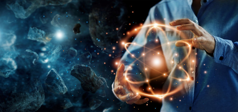 .Abstract science, hands holding atomic particle, nuclear energy imagery and network connection on meteorites space planets background.