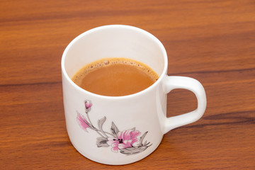 Cup of tea with milk isolated on wooden background