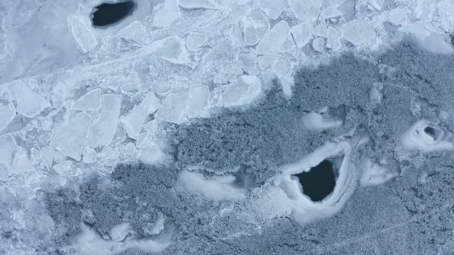 Flying over frozen river ice breakup