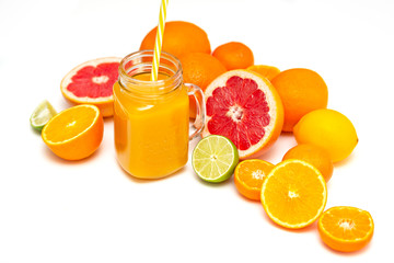 Freshly blended yellow and orange fruit smoothie in glass jar. Glass jar mugs with orange health smoothie, lime, grapefruit, lemon, tangerine. Selective focus. Copy space. Vegetarian food concept.  