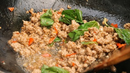 Fied meat with basil leaf in pan