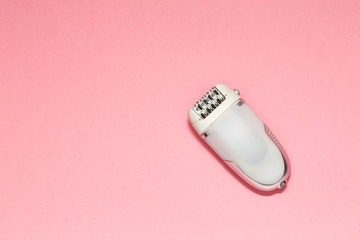 Epilator on a pink background. Depilatory. Removal of unwanted hair. Spa and Female treatments. Epilation concept