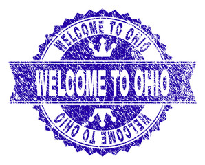 Obraz premium WELCOME TO OHIO rosette stamp watermark with distress style. Designed with round rosette, ribbon and small crowns. Blue vector rubber watermark of WELCOME TO OHIO text with corroded style.