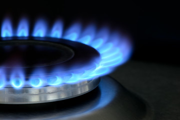 Natural gas burning on kitchen gas stove on black