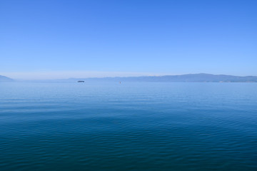 Tourist ship is sailing on Ohrid Lake. Mountain background. Ohrid, Macedonia.