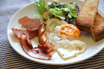 English breakfast fried egg bacon sausage bread and salad