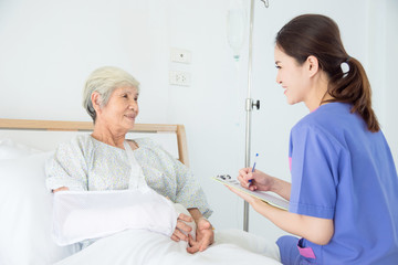 Obraz premium Beautiful asian nurse visiting senior female patient at hospital bed