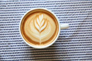 cappuccino or Latte art coffee made from milk on the wood table in coffee shop