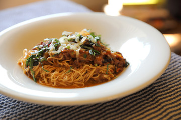 spaghetti Bolognese with minced beef and tomato sauce garnished with parmesan cheese and basil , Italian food
