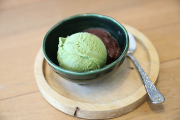 Japanese green tea ice cream with red bean topping on wooden table in coffee shop