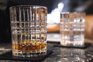 A glass of whiskey, bourbon, brandy, rum or brandy. Expensive drink in the bar. Male strong alcohol. Refined taste. Long exposure. Elite distillery. Scotch or Irish whiskey.
