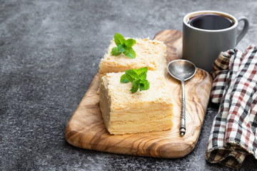 Napoleon cake slices with cup of coffee on gray table