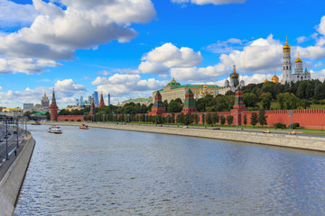 View of Moskva river and Moscow Kremlin in sunny day against blue sky with white clouds