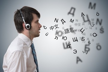 Young man with headphones is learning different foreign languages.
