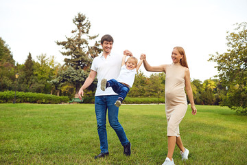 Obraz premium Happy family playing with baby in the park.