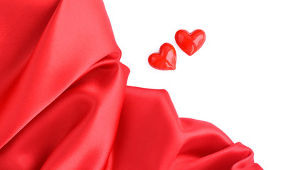 Valentines Day background. Two decorative hearts and red satin fabric with space for your text
